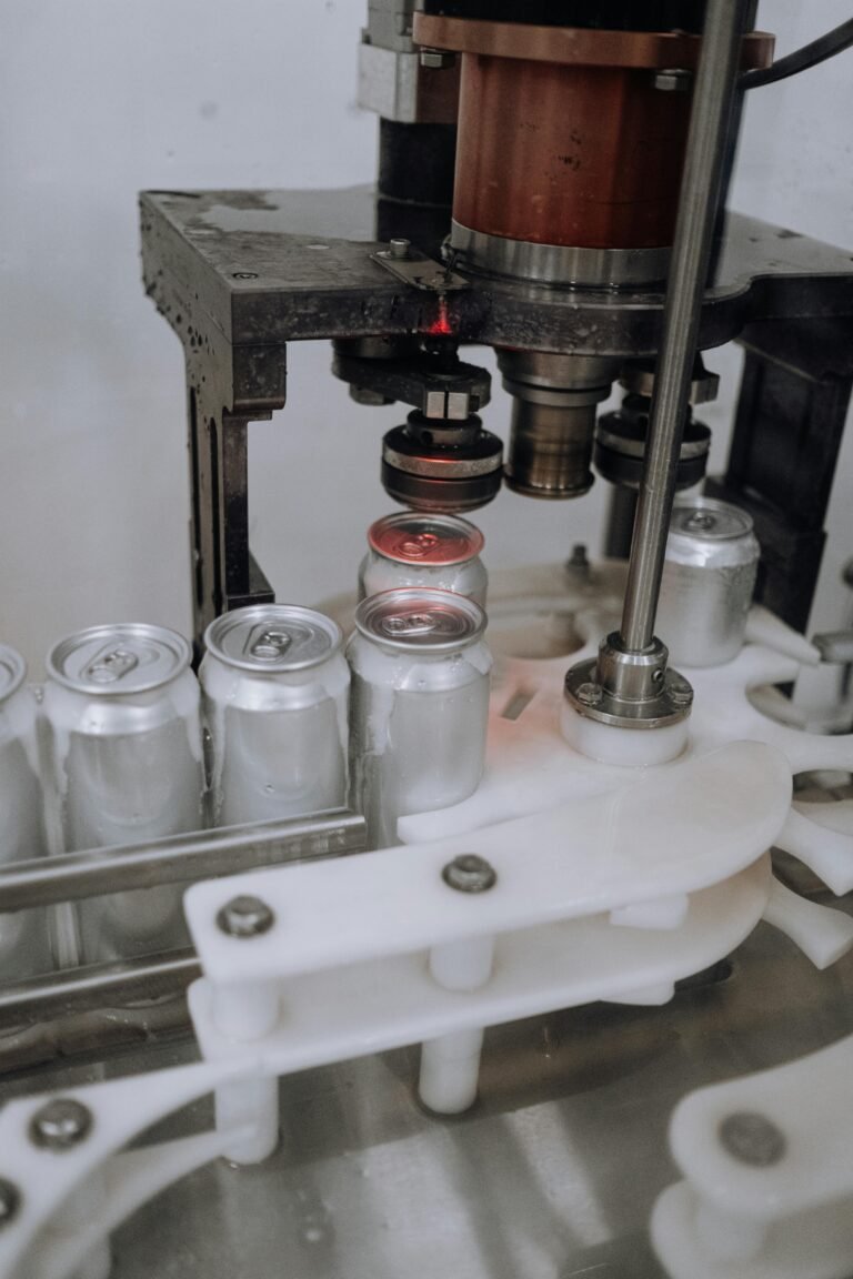Close-up of beverage cans on an automated assembly line in a factory.